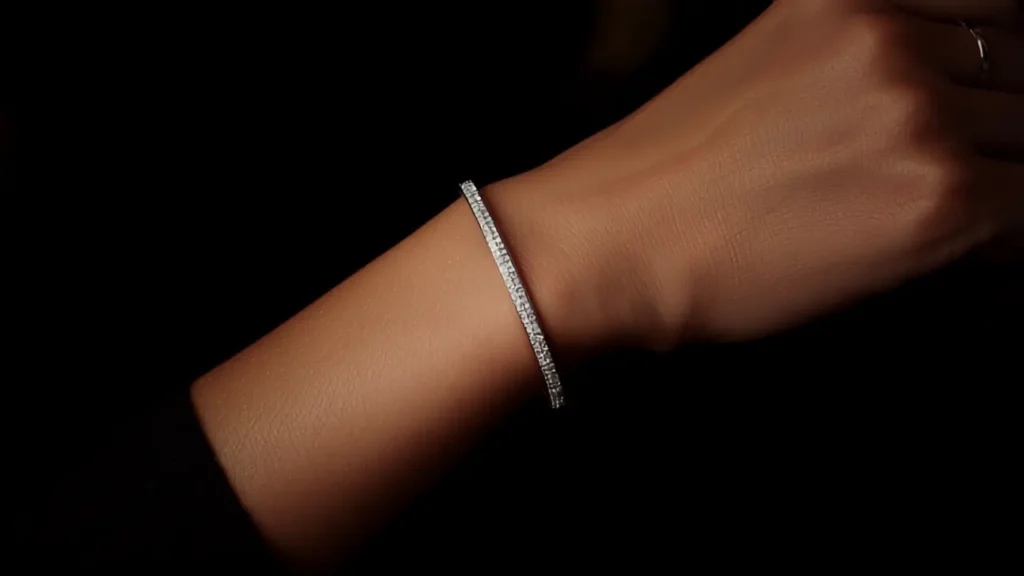 Pavé crystal bangle bracelet on a woman's wrist against a dark background